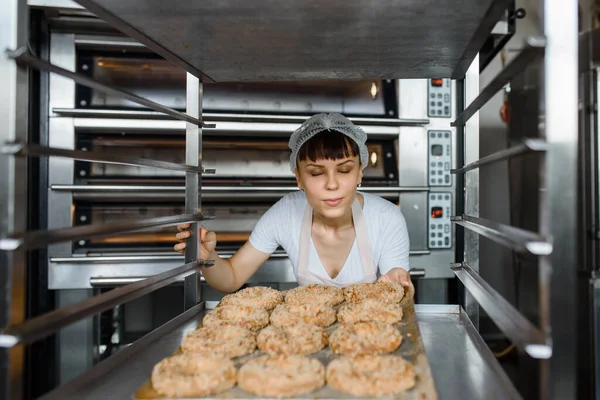 Zbliżenie Młodej Kaukaskiej Kobiety Piekarz Trzyma Tacę Świeżymi Bajglami Patrzy — Zdjęcie stockowe