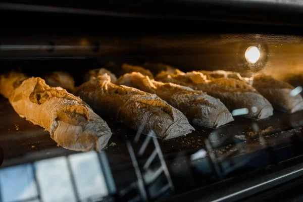 Bir fırın imalatında ekmek ekmeği pişirme işlemini kapat. Elektrikli fırında gagalı ekmek.