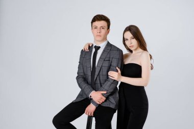 Beyaz arka planda takım elbiseli genç bir çiftin portresi.