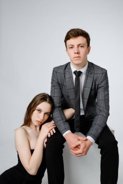 Beyaz arka planda takım elbiseli genç bir çiftin portresi.