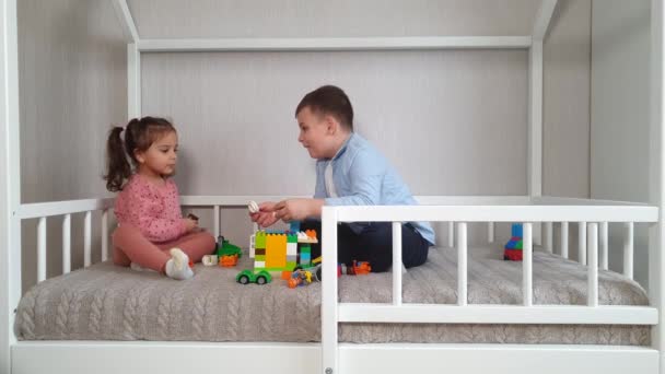 Two Children Brother Sister Sitting Montessori Bed Playing Toy Bricks — Stock Video