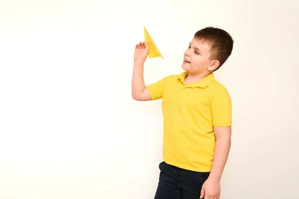 Child Boy Yellow Shirt Holding Paper Airplane White Background Copy — Stock Photo, Image