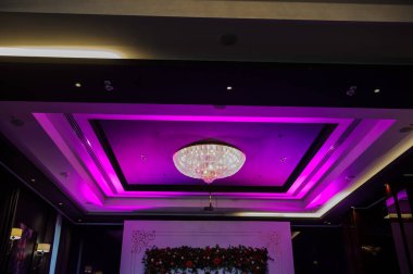 Restoran, menekşe ışığında avize lüksüyle dekore edilmiş.