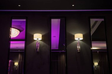 Restoran, menekşe ışığında avize lüksüyle dekore edilmiş.