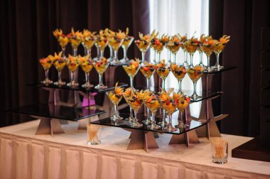 Düğün süsleme ziyafetinde bir stantta bir sürü farklı meyve var: portakal, kivi, fisali, çilek ve mavi kızılcık.