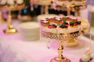 Farklı tatlılarla süslenmiş düğün dörtlüsü.