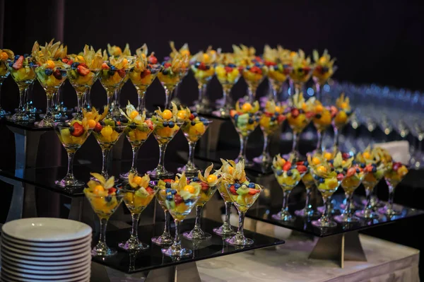 Düğün süsleme ziyafetinde bir stantta bir sürü farklı meyve var: portakal, kivi, fisali, çilek ve mavi kızılcık.