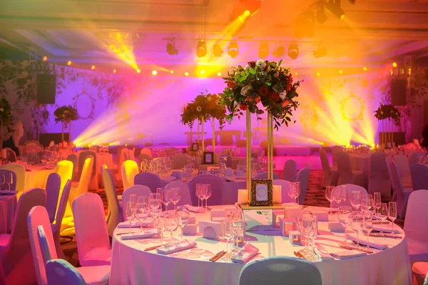 Düğün resepsiyonu masası pembe şakayık ve güllerle süslenmiş. Şarap bardakları, çatallar, bıçaklar, tabaklar