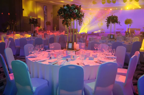 Düğün resepsiyonu masası pembe şakayık ve güllerle süslenmiş. Şarap bardakları, çatallar, bıçaklar, tabaklar