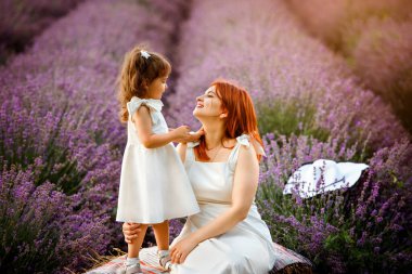 Anne ve kızı lavanta tarlasında aynı beyaz elbiseyi giyiyor..