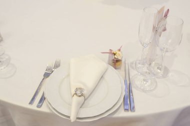 Restoranda. Tabak bıçaklı, çatallı ve peçeteli beyaz masa..