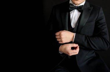 Siyah takımını siyah arka planda düzenleyen adama yaklaş. Metin için boşluk kopyala