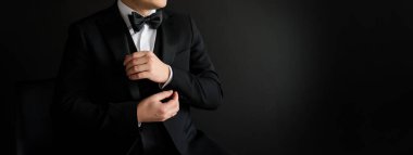 Siyah takımını siyah arka planda düzenleyen adama yaklaş. Metin için boşluk kopyala