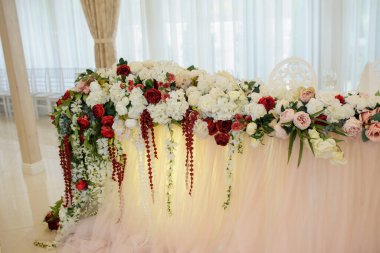 Düğün masasını çiçeklerle, güllerle ve şakayıklarla süsleyin.