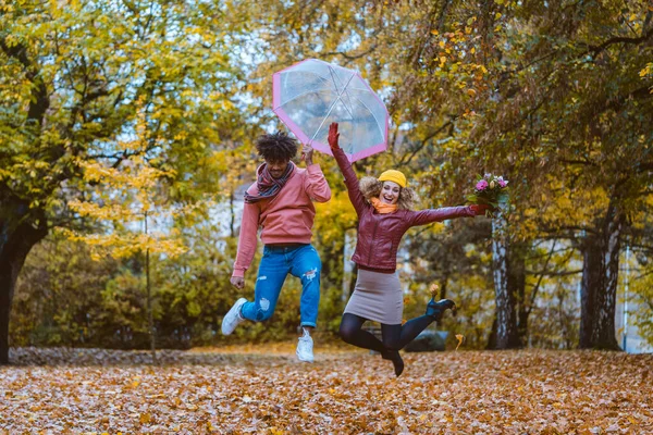Mężczyzna Kobieta Skaczą Radośnie Jesiennym Parku Pomimo Pogody — Zdjęcie stockowe