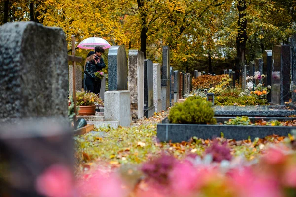 Могили на цвинтарі восени з парою траурних померлих — стокове фото