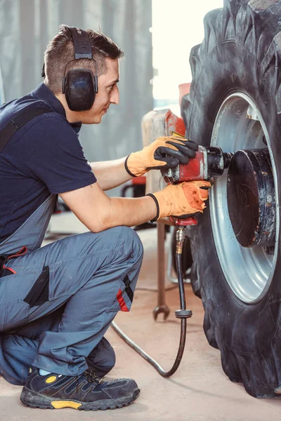 farm machine mechanic working on wheel