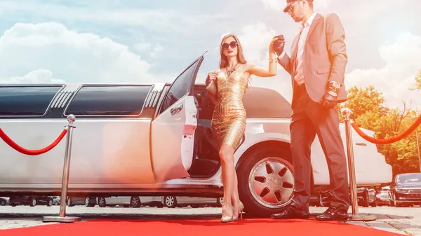 Řidič pomáhá VIP žena nebo hvězda z limuzíny na červeném koberci — Stock fotografie