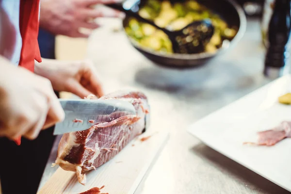 Detail záběr kuchaře krájení Parma šunka pro použití v misce — Stock fotografie