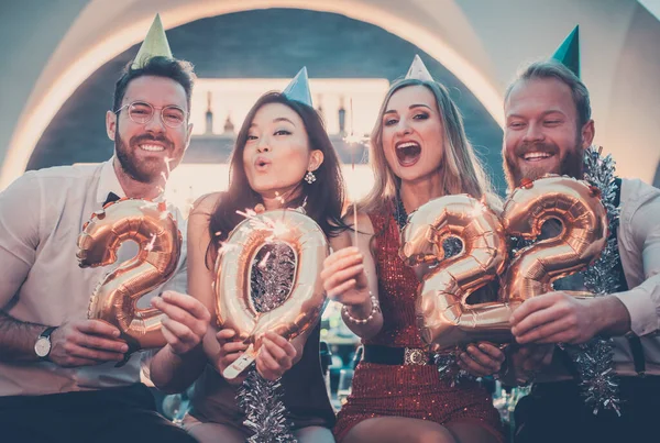 Hommes et femmes célébrant la nouvelle année 2022 — Photo