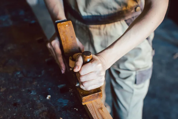 Primo piano sulla mano della donna falegname con pialla in legno — Foto Stock