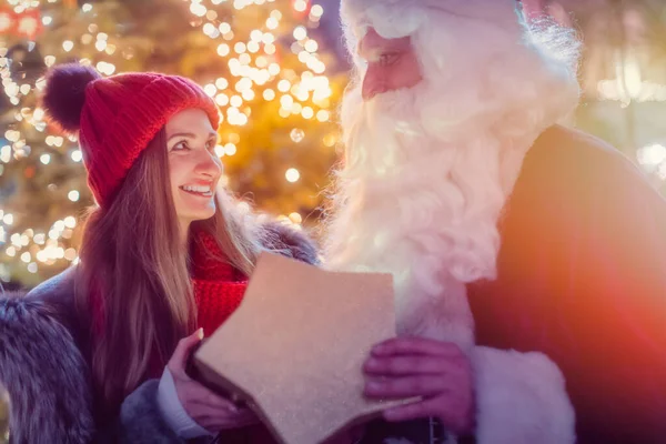 Санта Клаус подарував прекрасну дівчину з подарунком. — стокове фото