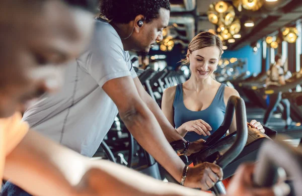 Grupo de amigos diversidade exercitando-se em bicicleta no ginásio — Fotografia de Stock