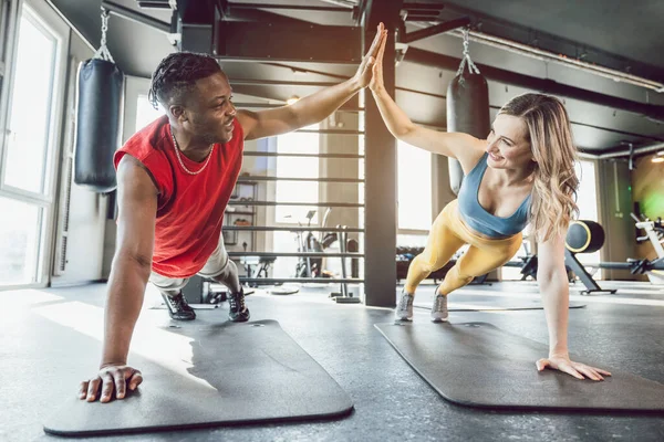 Ajuste hombre y mujer en el gimnasio ejercitando abdominales — Foto de Stock