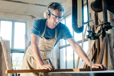 Bandodaki marangoz atölyesinde testere kullanmış.
