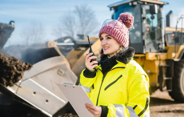 Kvinna med walkie talky på komposteringsanläggning som skickar leveranser — Stockfoto