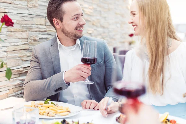 Gente alegre disfrutando de bebidas y comida en el restaurante italiano —  Fotos de Stock