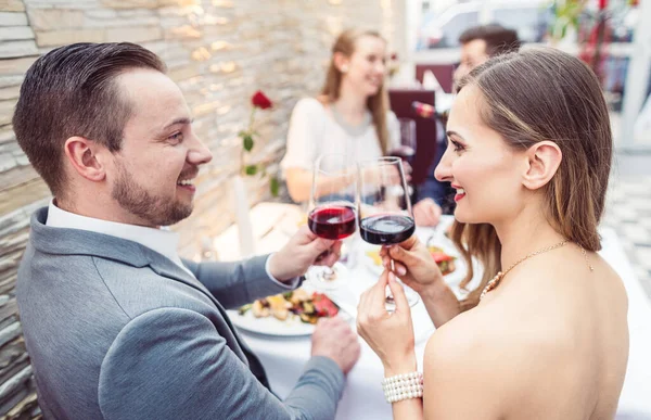 Hombres y mujeres pasando un buen rato con comida y bebida en el restaurante — Foto de Stock