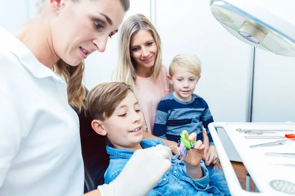 Dentist and boy patient choosing the dental braces in clinic — Stock Photo, Image