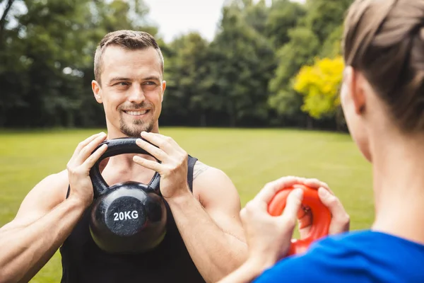 Happy man working out in park with trainer — Stockfoto
