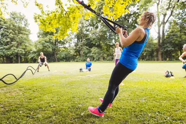 Junge Frau trainiert mit Gummiband im Park — Stockfoto