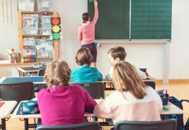 Öğretmen okulda tahtaya ilginç şeyler yazarken sınıf dinliyordu.