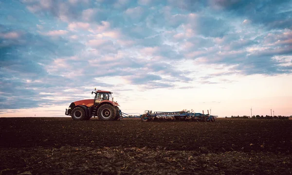 日落时田间耕作土壤的拖拉机 — 图库照片