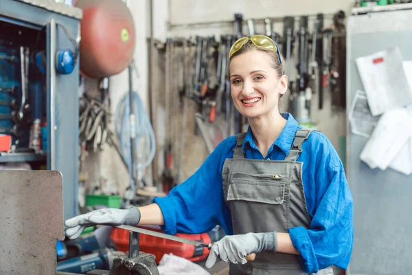 Kvinnlig Arbetare Metallverkstad Tittar Kameran Som Omges Arbetsverktyg — Stockfoto