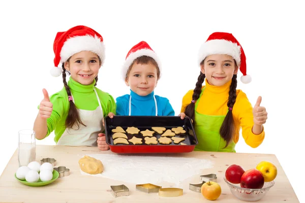 Tre bambini sorridenti con cucina natalizia — Foto Stock