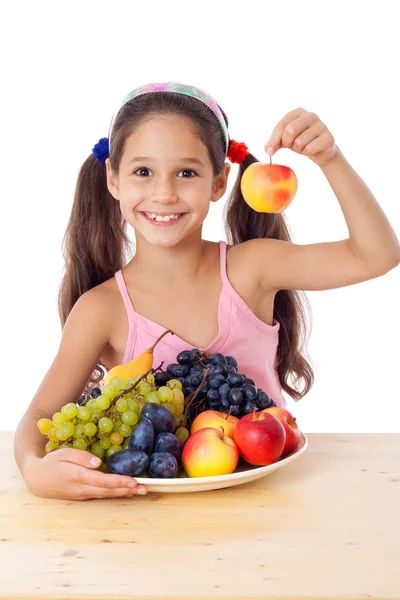 Fille avec pomme et assiette de fruits — Photo