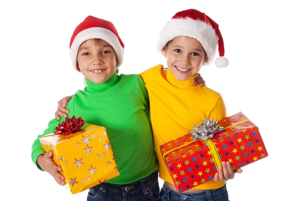 Smiling kids in Santa hats with gift boxes — Stock Photo, Image