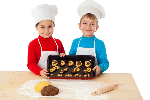 Two kids with baking on oven-tray — Stock Photo, Image