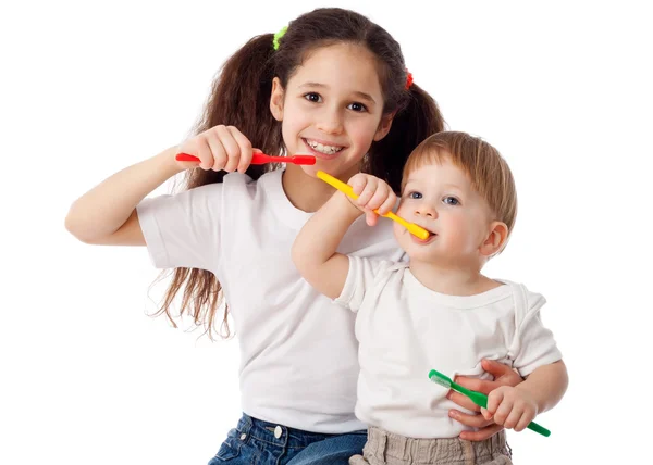 Girl teaches boy brushing teeth Royalty Free Stock Photos