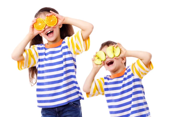 Duas crianças engraçadas com frutas nos olhos — Fotografia de Stock