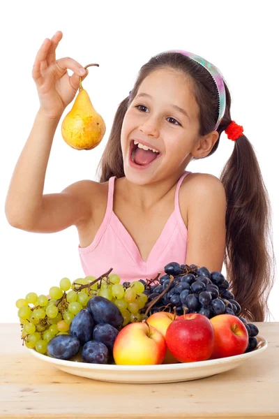 Menina com pêra e prato de frutas — Fotografia de Stock
