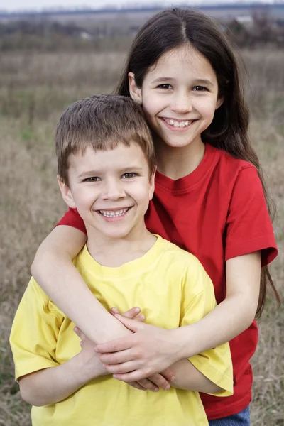 Due bambini sorridenti in piedi insieme — Foto Stock