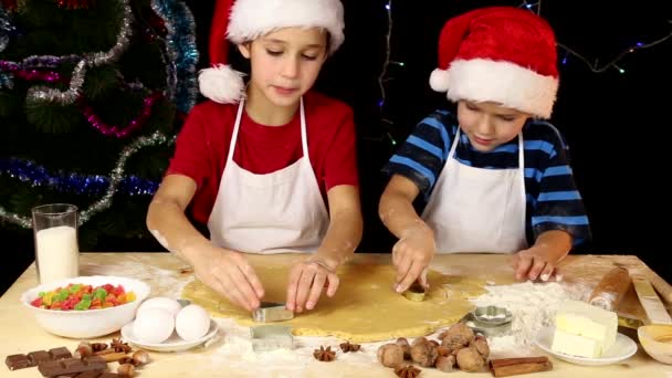 Двое детей режут тесто — стоковое видео