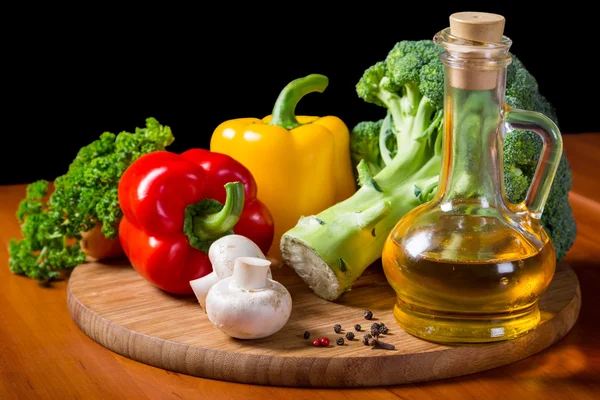 Verduras frescas con aceite en la tabla de cortar —  Fotos de Stock