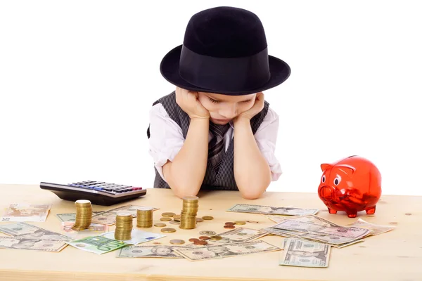 Ledsen pojke vid bordet med pengar — Stockfoto