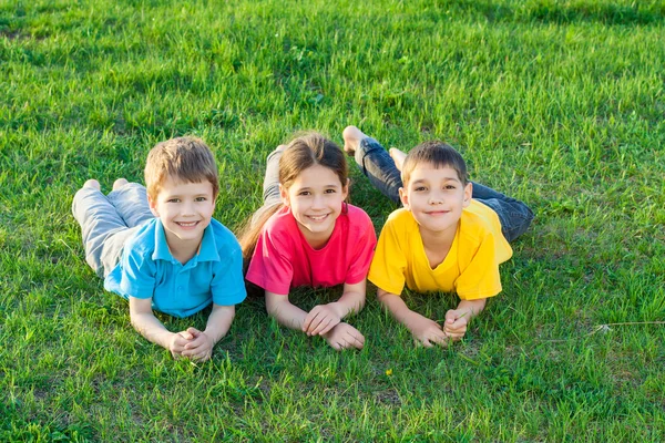 Tre leende barn på ängen — Stockfoto